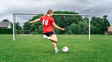 Pige sparker på mål til fodbold