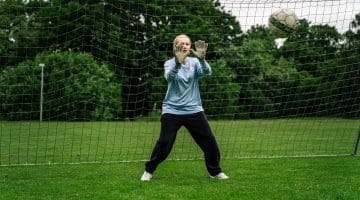 Pige står på mål til fodbold på efterskole. Målmand